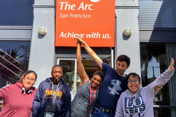 Group of people in front of the Arc sign
